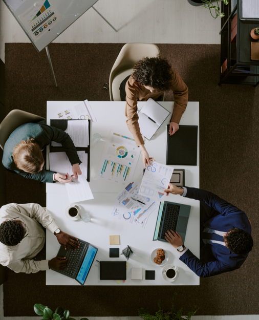 people working together at a desk, pictured from above